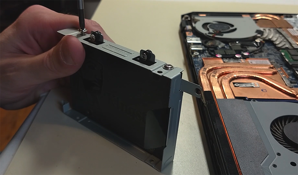 View of a solid-state drive being installed in a laptop